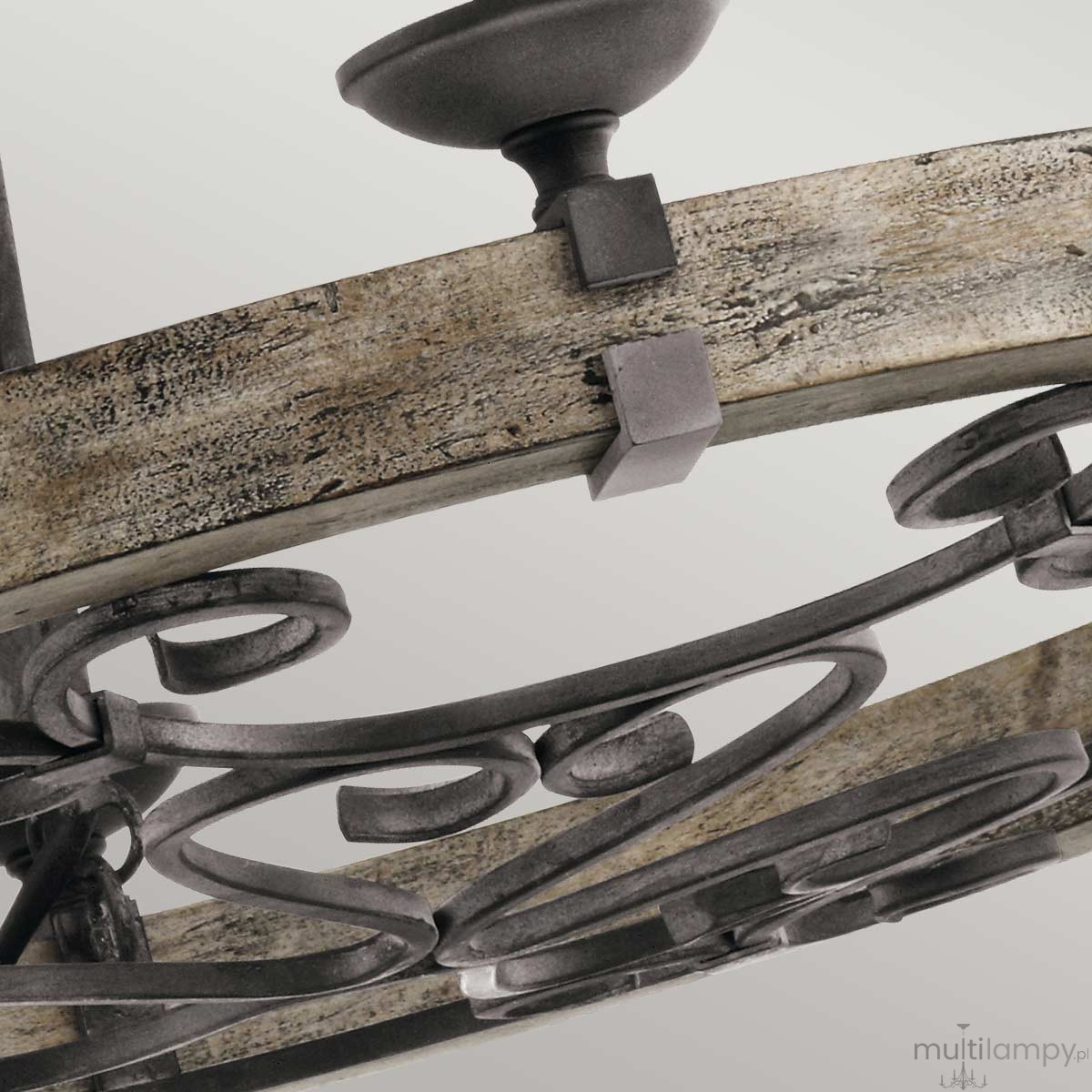 Lampa wisząca Taulbee z postarzanym cynkiem, z sześcioma oprawkami E14. Widoczna konstrukcja z metalowymi detalami w formie ozdobnych spirali oraz surowym, drewnianym elementem w odcieniach szarości i brązu.