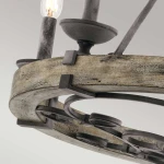 Lampa wisząca Taulbee z postarzanym cynkiem, z sześcioma miejscami na żarówki E14. Okrągła konstrukcja z dekoracyjnymi elementami metalowymi i drewnianym wykończeniem. Widok z góry, ukazujący detale mocowania i żarówki.