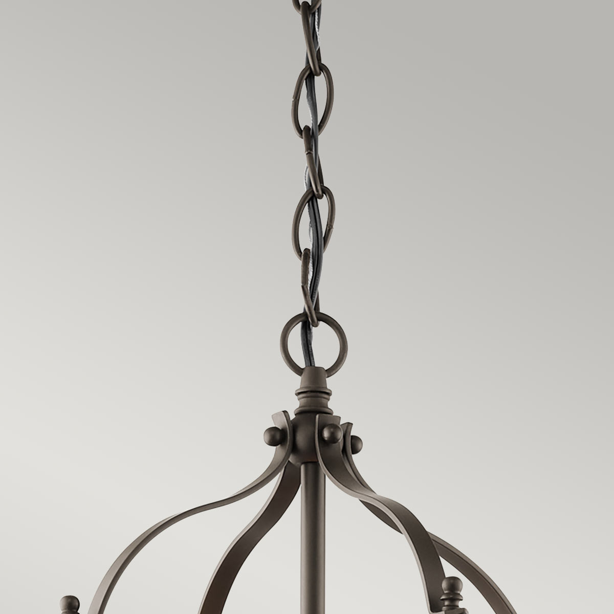 Larkin S lampa wisząca w kolorze starym brązie, z metalowymi elementami. Widoczny łańcuch mocujący oraz dekoracyjne detale. Ujęcie z góry, ukazujące kształt i konstrukcję lampy.
