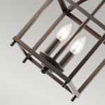 Larkin S lampa wisząca w kolorze stary brąz, z dwoma gniazdami E14, w kształcie prostokątnej klatki. Widoczne dwie żarówki o kształcie łezki. Ujęcie z góry, podkreślające detal konstrukcji i elegancki design.