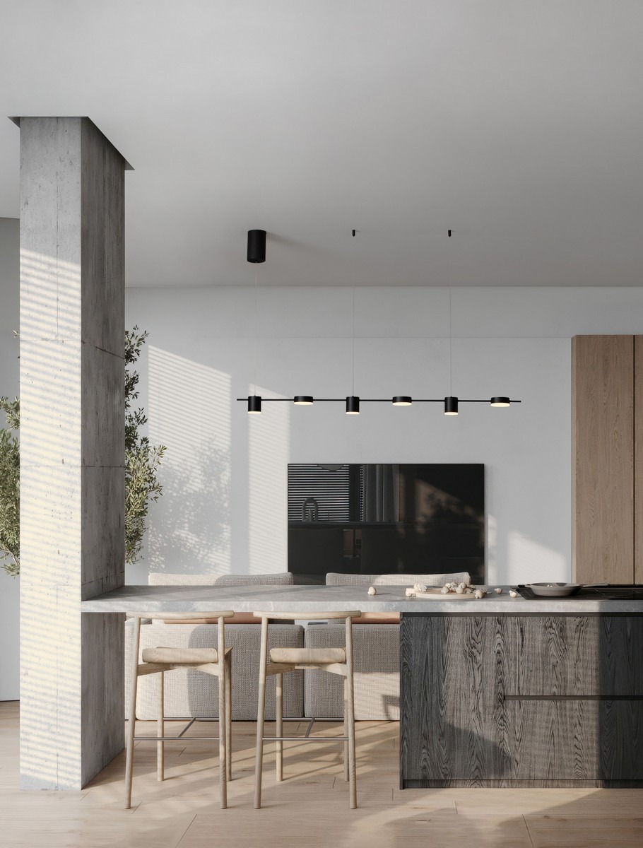 Lampa wisząca Orelvio z sześcioma źródłami LED, 20W, w kolorze czarnym. Zamontowana nad wyspą kuchenną, z minimalistycznym designem. Oświetlenie w nowoczesnym wnętrzu, z drewnianymi krzesłami i betonową kolumną w tle.
