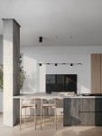 Lampa wisząca Orelvio z sześcioma źródłami LED, 20W, w kolorze czarnym. Zamontowana nad wyspą kuchenną, z minimalistycznym designem. Oświetlenie w nowoczesnym wnętrzu, z drewnianymi krzesłami i betonową kolumną w tle.