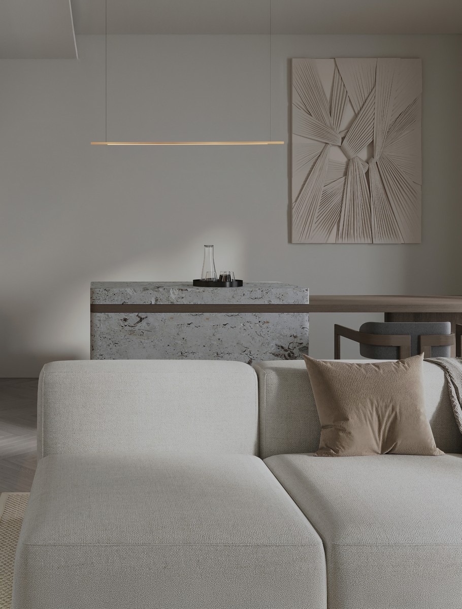 Lampa wisząca Monterzo 1xLED 20W CCT w kolorze złotym, o minimalistycznym kształcie, zawieszona nad stołem. Tło w neutralnych odcieniach, z dekoracyjną ścianą i nowoczesnym blatem w kuchni. Wysoka funkcjonalność i elegancki design.