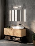 Kinkiet Marvona 1xLED 14W 4000K w kolorze białym, zamontowany nad lustrem w nowoczesnej łazience. Prosty, prostokątny design, umieszczony na tle szarej ściany, obok umywalki i drewnianej szafki. Oświetlenie w minimalistycznym stylu.