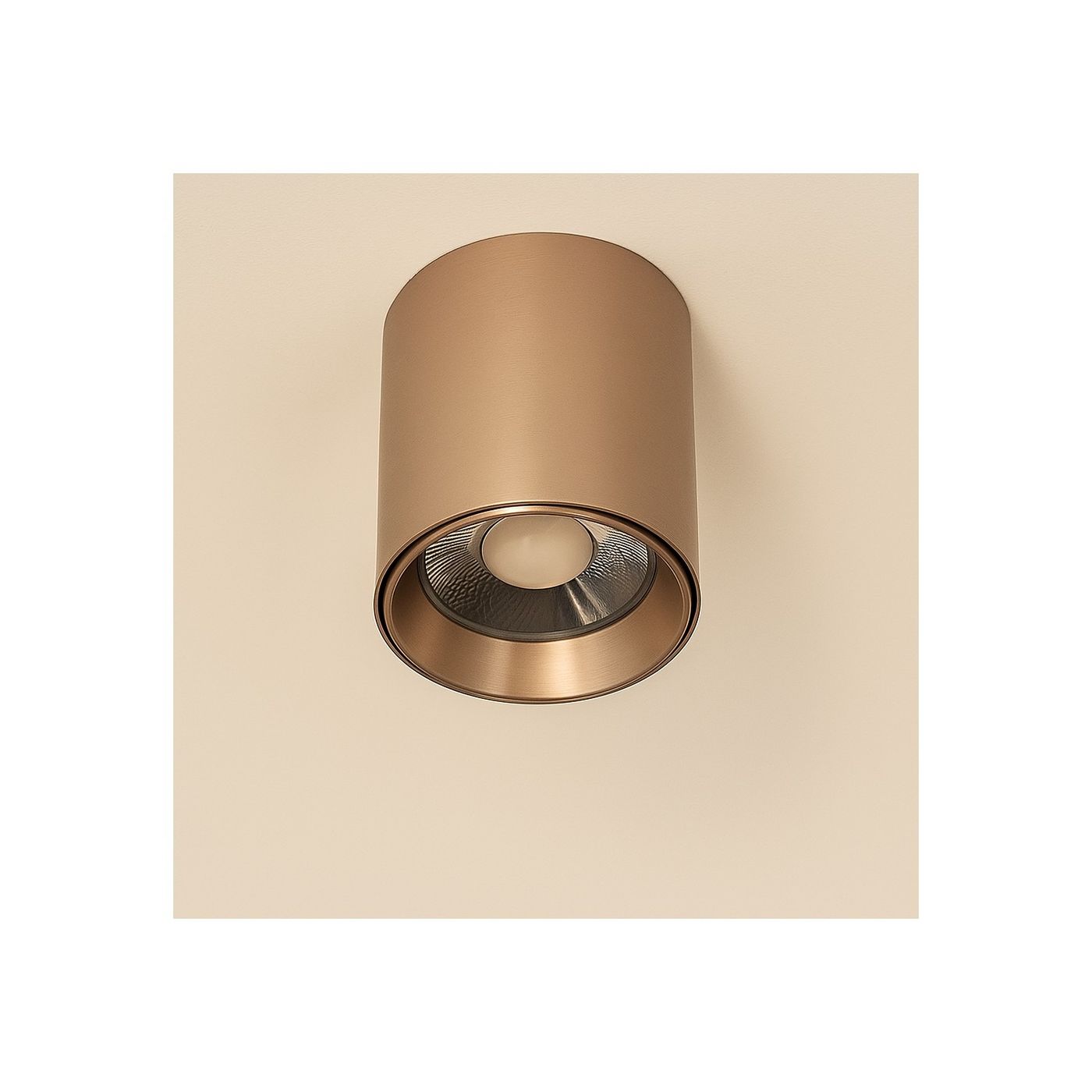 Lampa sufitowa LED 15W CCT w kolorze kawowym, cylindryczna z metaliczną obudową. Zainstalowana na suficie, z widoczną soczewką w centralnej części. Prosty, elegancki design, bez dodatkowych zdobień. Tło jasne, jednolite.