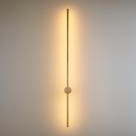 Kinkiet LED Sparo H120 o mocy 22W, barwie światła 3000K, w złotym połysku. Produkt montowany na ścianie, o prostokątnym kształcie z centralnym, okrągłym elementem. Emituje ciepłe, rozproszone światło na jasnym tle.