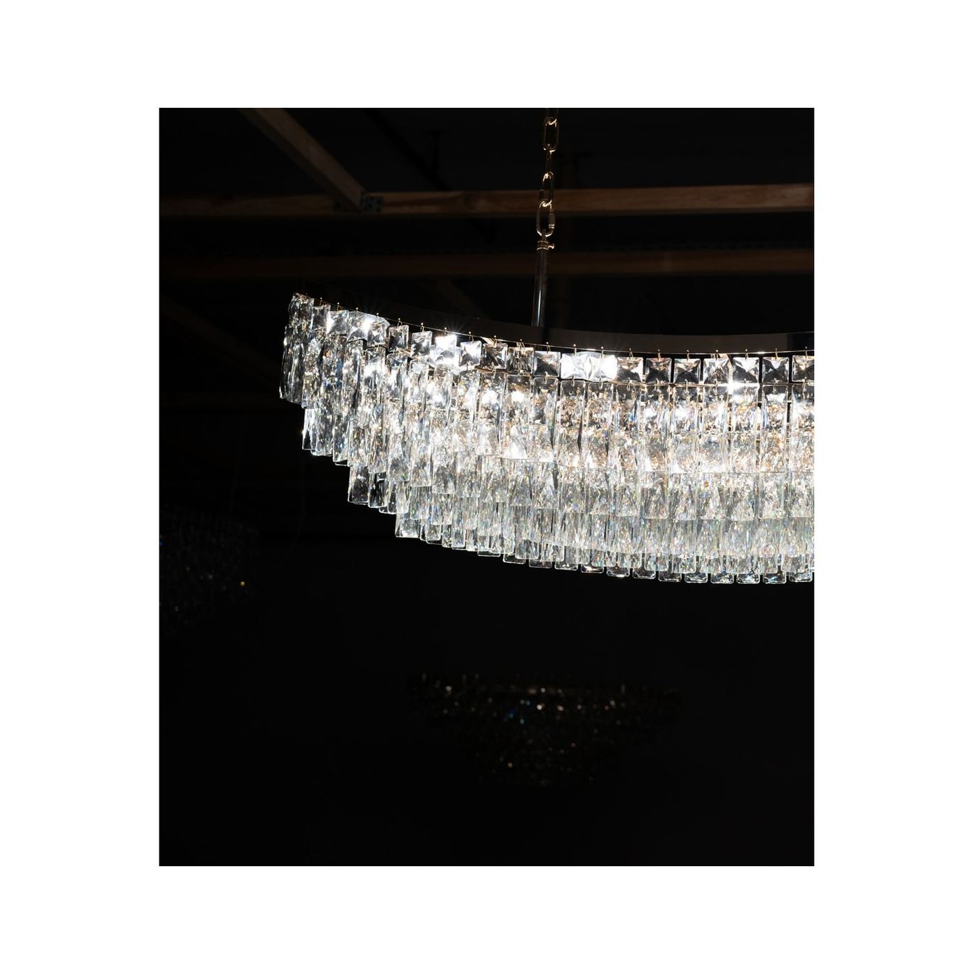 Lampa wisząca Zambezi 18xE14 w złotym kolorze, z przezroczystymi, szklanymi elementami w formie prostokątnych kryształków, zawieszona na złotym łańcuchu. Ujęcie z góry, na ciemnym tle, eksponujące elegancki design i refleksy świetlne.