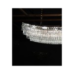Lampa wisząca Zambezi 18xE14 w złotym kolorze, z przezroczystymi, szklanymi elementami w formie prostokątnych kryształków, zawieszona na złotym łańcuchu. Ujęcie z góry, na ciemnym tle, eksponujące elegancki design i refleksy świetlne.