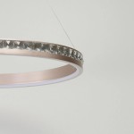 Lampa wisząca Camelia 1xLED 41W w złotym kolorze, z okrągłym metalowym ramieniem i kryształowym zdobieniem. Ujęcie z bliska, pokazujące detal krawędzi lampy oraz miękkie, rozproszone światło LED. Tło jasne, proste.