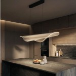 Lampa wisząca Manta 1xLED 38W w kolorze czarnym, o opływowym kształcie, zawieszona nad ciemnym blatem kuchennym. W tle widoczne drewniane elementy zabudowy kuchennej oraz akcesoria. Włączona, emitująca ciepłe światło.