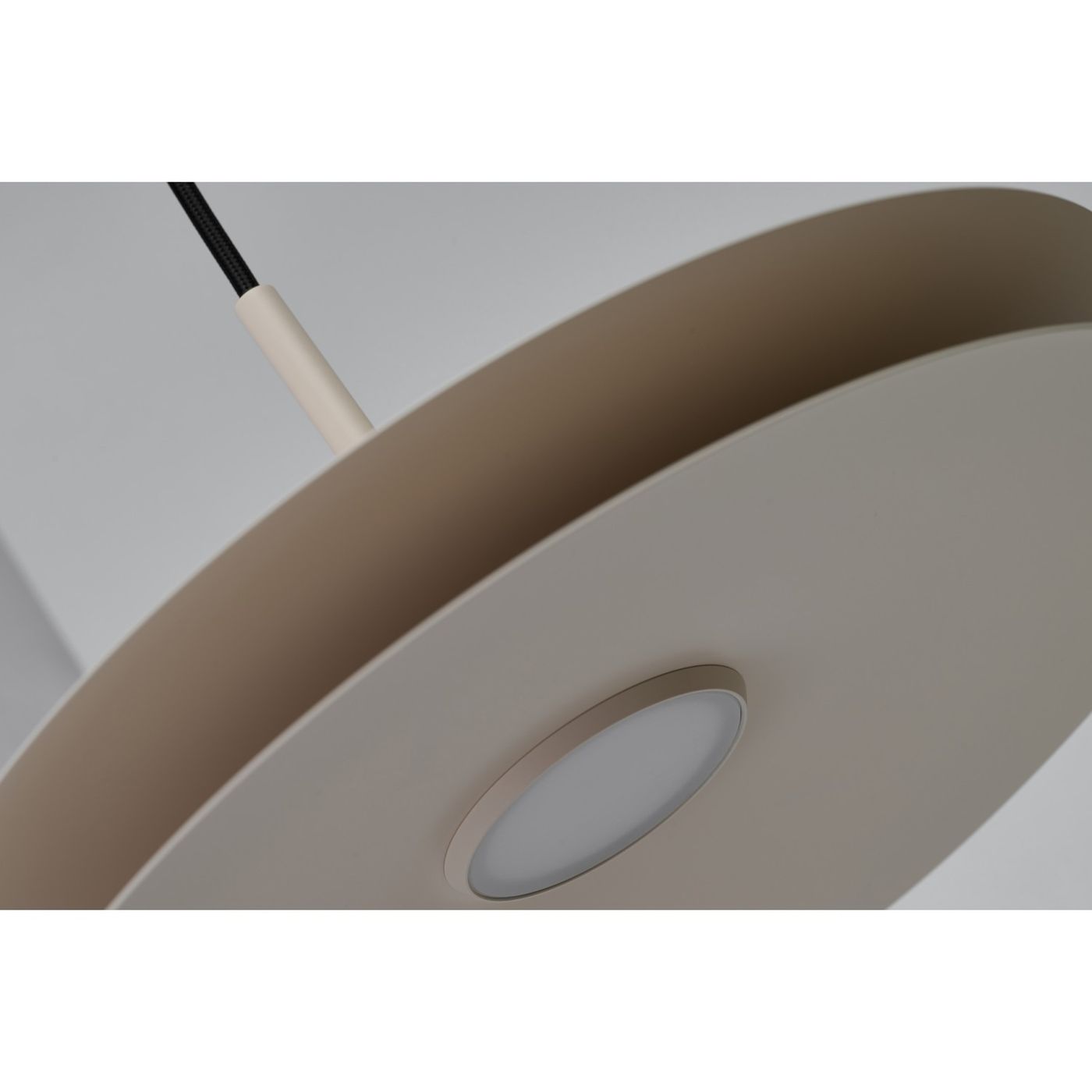 Lampa wisząca LED 12W w kolorze beżowym, o okrągłym kształcie. Widoczna metalowa podstawa z matowym wykończeniem oraz okrągły klosz z wbudowanym źródłem światła. Zawieszona na czarnym przewodzie.