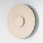 Kinkiet Ripple D50 w kolorze beżowym, wykonany z matowego materiału. Okrągły, z wyraźnym, centralnym wypukłym elementem oraz falistą fakturą. Zawiera źródło światła LED o mocy 6W, montowany na ścianie.