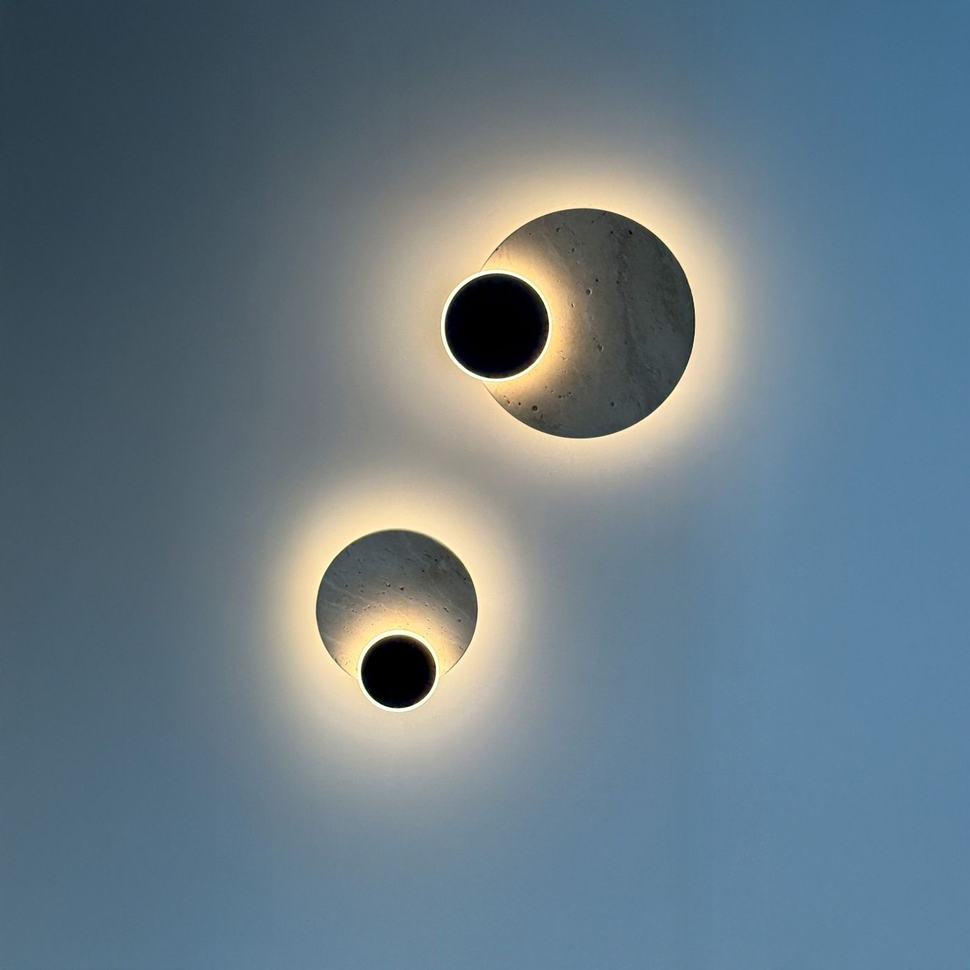 Kinkiet Eclipse 2xLED 10W w kolorze czarnym. Dwa okrągłe elementy o matowej fakturze, z podświetleniem wokół ciemnych wnętrz. Zawieszone na ścianie, o różnych rozmiarach, w nowoczesnym stylu. Idealne do dekoracji wnętrz.