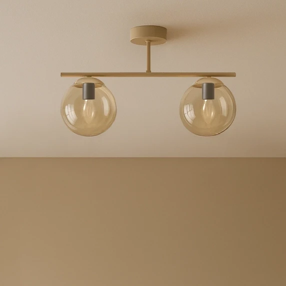 Beżowa lampa sufitowa Felix z dwoma kloszami w bursztynowym kolorze, zamontowana na metalowej belce. Klosze mają okrągły kształt i są przezroczyste, z widocznymi mocowaniami. Lampa umieszczona na jasnym tle.