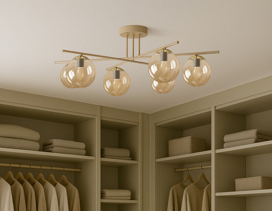 Beżowa lampa sufitowa Felix z sześcioma kloszami w bursztynowym kolorze, zawieszona na metalowej konstrukcji. Klosze mają okrągły kształt, a lampa umieszczona jest w prostym, nowoczesnym wnętrzu z szafą.