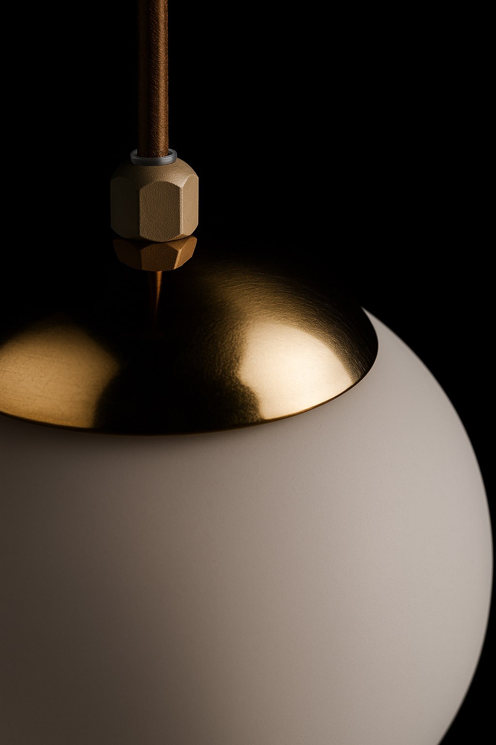 Lampa wisząca Savia z kloszem w kolorze beżowym i złotą, błyszczącą osłoną. Ujęcie zbliżeniowe pokazuje detale mocowania oraz fakturę klosza. Produkt zawieszony na brązowym przewodzie, w ciemnym tle.