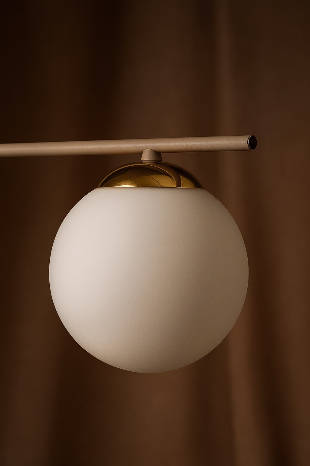 Beżowa lampa sufitowa Savia z sześcioma miejscami na żarówki E14. Okrągła, matowa klosz z białego szkła, złota oprawa na górze. Produkt zamontowany na prostym, poziomym ramieniu. Tło w odcieniach brązu.