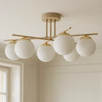 Lampa sufitowa Savia z sześcioma kulistymi kloszami w kolorze białym, umieszczona na beżowej konstrukcji. Klosze z matowego szkła, zawieszone na metalowych ramionach, które rozchodzą się w różnych kierunkach. Montowana do sufitu.