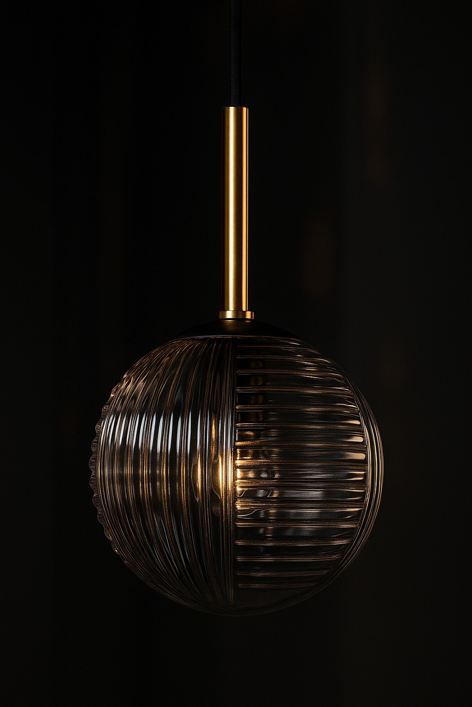 Lampa wisząca Fado z kloszem w kolorze czarnym i grafitowym, o okrągłym kształcie z żłobieniami, zawieszona na złotej, metalowej rurce. Wnętrze klosza ma widoczny gwint G9. Produkt prezentowany na ciemnym tle.