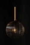 Lampa wisząca Fado z kloszem w kolorze czarnym i grafitowym, o okrągłym kształcie z żłobieniami, zawieszona na złotej, metalowej rurce. Wnętrze klosza ma widoczny gwint G9. Produkt prezentowany na ciemnym tle.