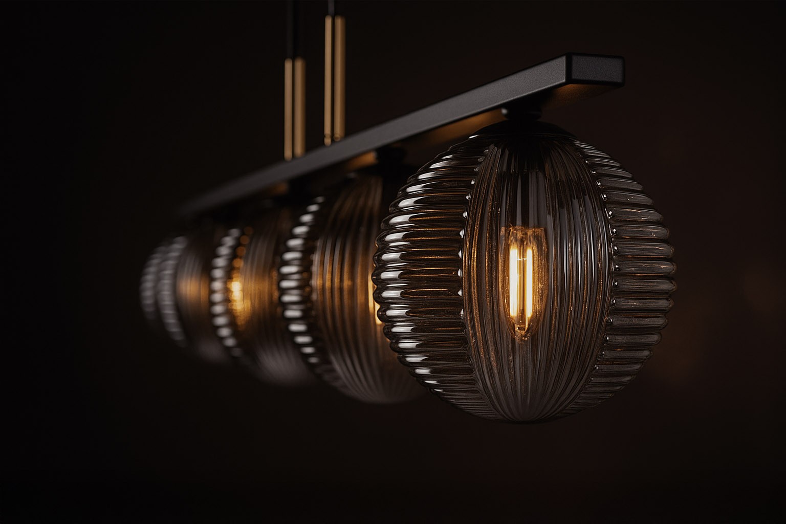 Lampa wisząca Fado w kolorze czarnym i grafitowym z pięcioma kloszami w kształcie kulistym, wykonanymi z teksturowanego szkła. Klosze zawieszone na prostokątnej podstawie, z widocznymi żarówkami G9, oświetlającymi przestrzeń.