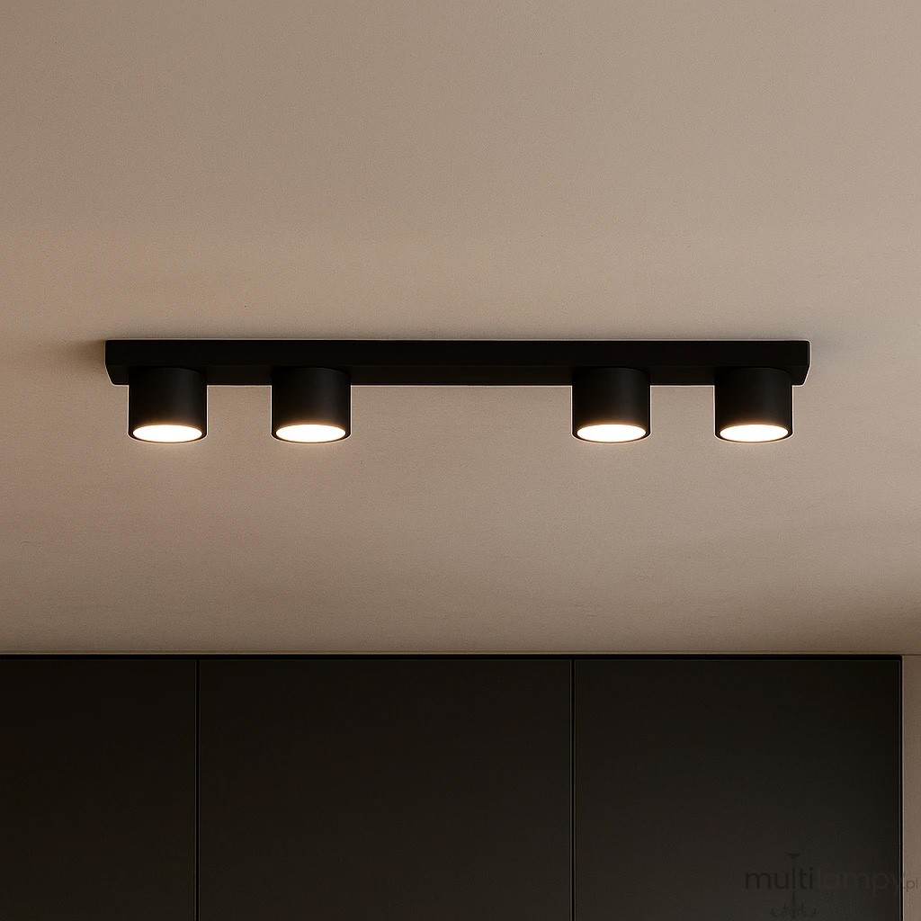 Lampa sufitowa Cruz z czterema punktami świetlnymi GX53, w kolorze czarnym. Ujęcie frontalne, zamontowana na suficie, z cylindrycznymi kloszami emitującymi światło. Prosta, nowoczesna konstrukcja na jednolitym tle.