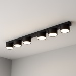 Cruz lampa sufitowa w kolorze czarnym, z sześcioma okrągłymi kloszami na żarówki GX53, zamontowana równolegle do sufitu. Prosta, nowoczesna forma, idealna do oświetlenia wnętrz.