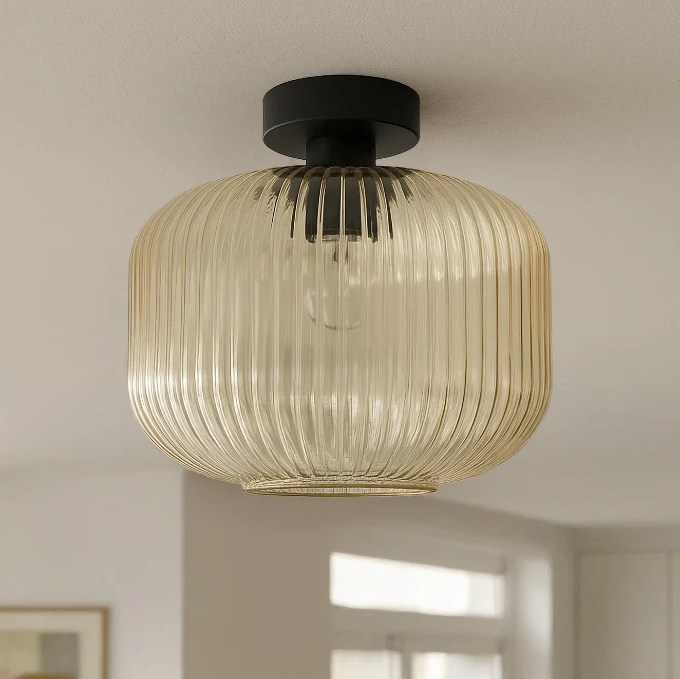 Lampa sufitowa Clark D30 z czarnym stelażem i bursztynowym kloszem z transparentnego szkła, o zaokrąglonym kształcie z pionowymi żłobieniami, zamontowana na suficie. Widoczna oprawka E27 wewnątrz klosza.