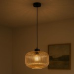 Lampa wisząca Clark D30 z czarnym metalowym zawieszeniem i bursztynowym, teksturowanym kloszem, o okrągłym kształcie. Zawieszona na cienkim kablu, emituje ciepłe światło. Tło w neutralnym kolorze, z widoczną zarysowaną ramą obrazu.