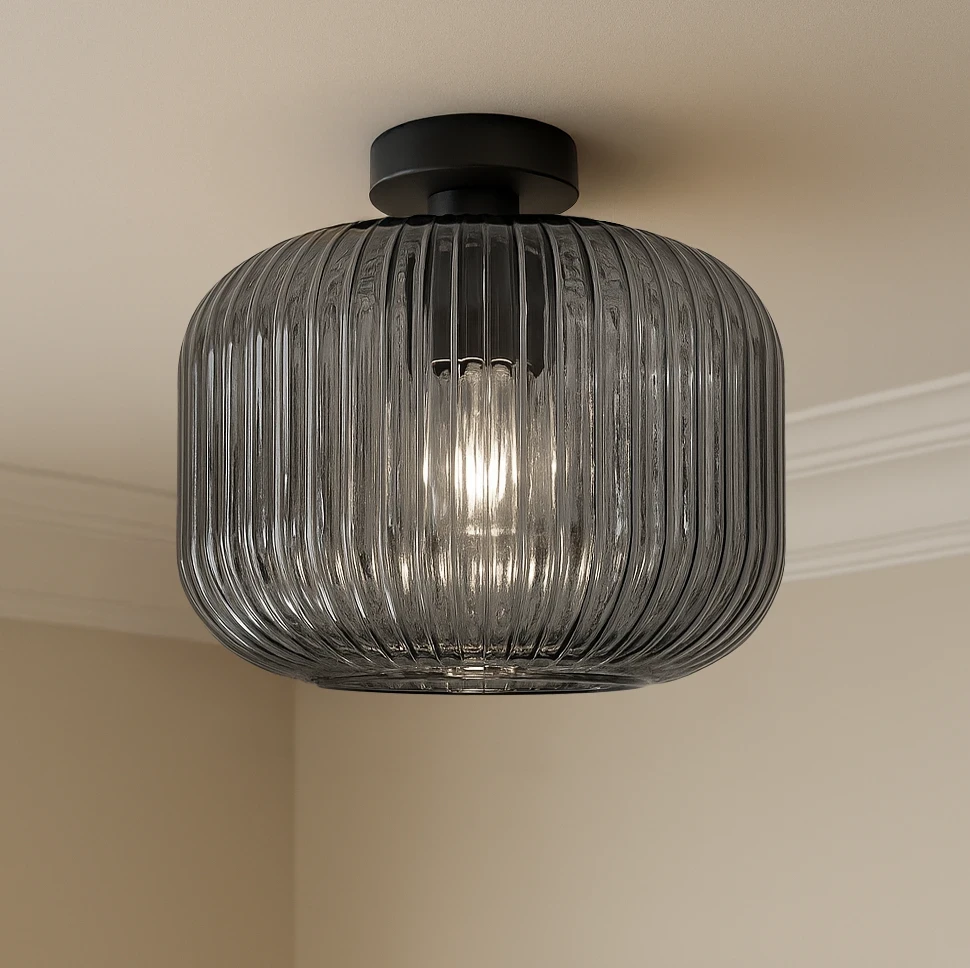 Lampa sufitowa Campo D30 z kloszem w kolorze grafitowym z żłobieniami, mocowana do sufitu, z miejscem na żarówkę E27. Widoczna wewnętrzna żarówka emituje światło przez przezroczysty klosz.