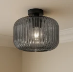 Lampa sufitowa Campo D30 z kloszem w kolorze grafitowym z żłobieniami, mocowana do sufitu, z miejscem na żarówkę E27. Widoczna wewnętrzna żarówka emituje światło przez przezroczysty klosz.