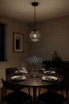 Lampa wisząca Campo D20 z czarnym stelażem i grafitowym szklanym kloszem w kształcie kuli, zawieszona nad okrągłym stołem. W tle elegancka aranżacja z kwiatami i zastawą stołową, stonowane kolory.