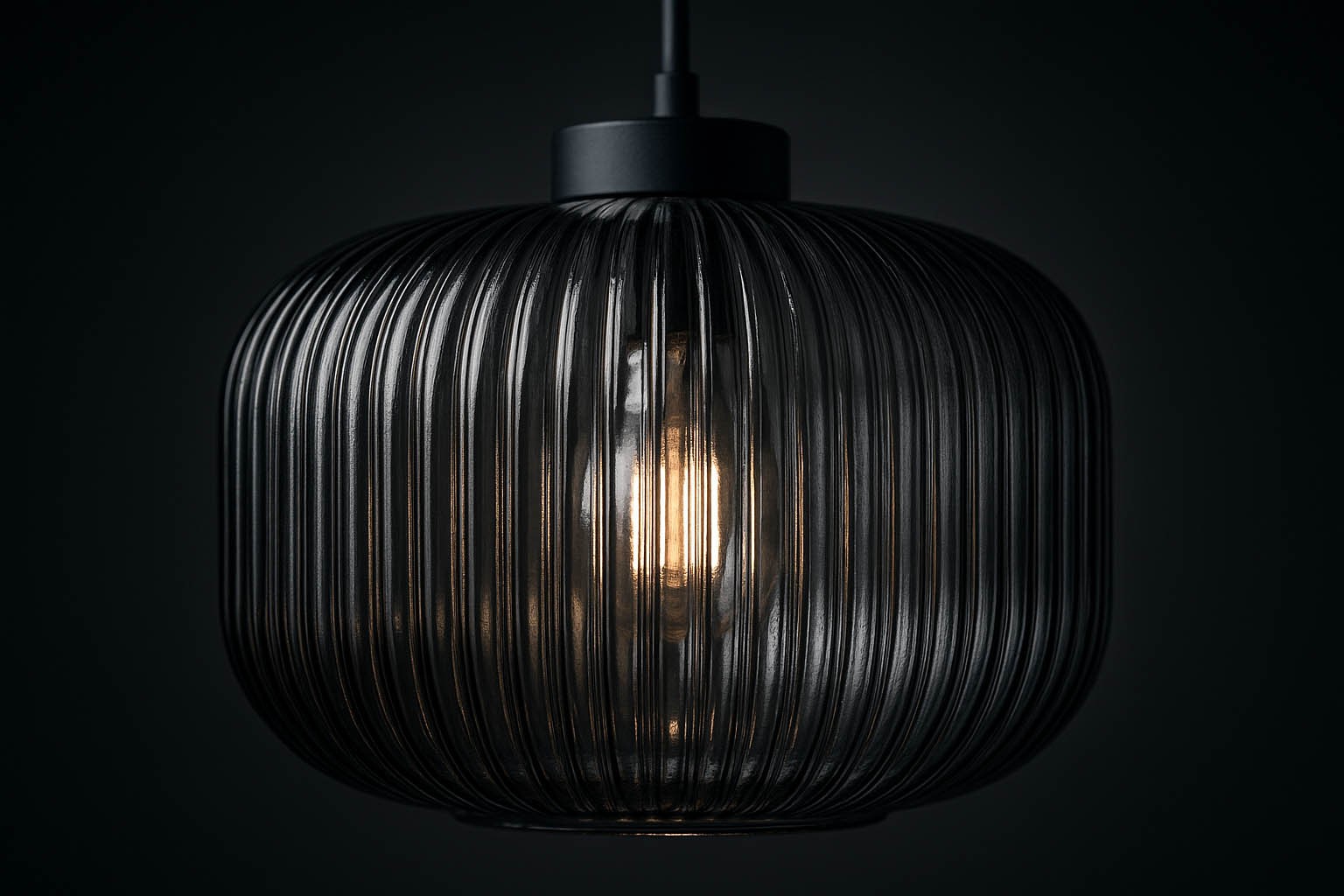 Lampa wisząca Campo D30 z kloszem w czarnym i grafitowym kolorze, o okrągłym kształcie z wyraźnymi żłobieniami. Zawiera żarówkę E27, wisi na cienkim przewodzie, a tło jest ciemne, podkreślające jej elegancki design.