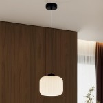 Lampa wisząca Sparta D20 z oprawą w kolorze czarnym i kloszem w białym, o kształcie prostokątnym z żłobieniami, zawieszona na cienkim przewodzie, umieszczona w jasnym wnętrzu z drewnianą ścianą w tle.