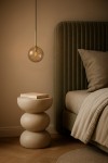 Czarna lampa wisząca Galaxy z bursztynowym kloszem, zawieszona na cienkim kablu. Obok znajduje się stół nocny z okrągłym, teksturowanym blatem i otwartą książką. Tło w odcieniach beżu, z miękkim oświetleniem.