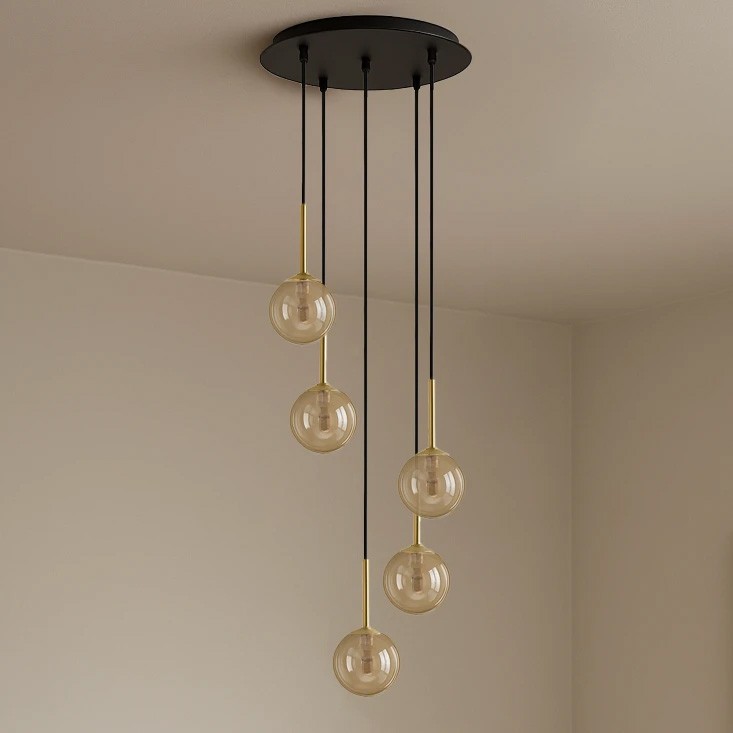 Lampa wisząca Galaxy 5xG9 w kolorze czarnym z bursztynowymi kloszami. Pięć szklanych kul zawieszonych na cienkich czarnych linkach, z metalowymi złotymi detalami. Ujęcie z dołu, pokazujące elegancki design.