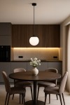 Lampa wisząca Savoy D16 w kolorze czarnym z białym, okrągłym kloszem, zawieszona na cienkim przewodzie. Produkt umieszczony w nowoczesnej kuchni, nad okrągłym stołem z brązowego drewna, otoczony czterema tapicerowanymi krzesłami.