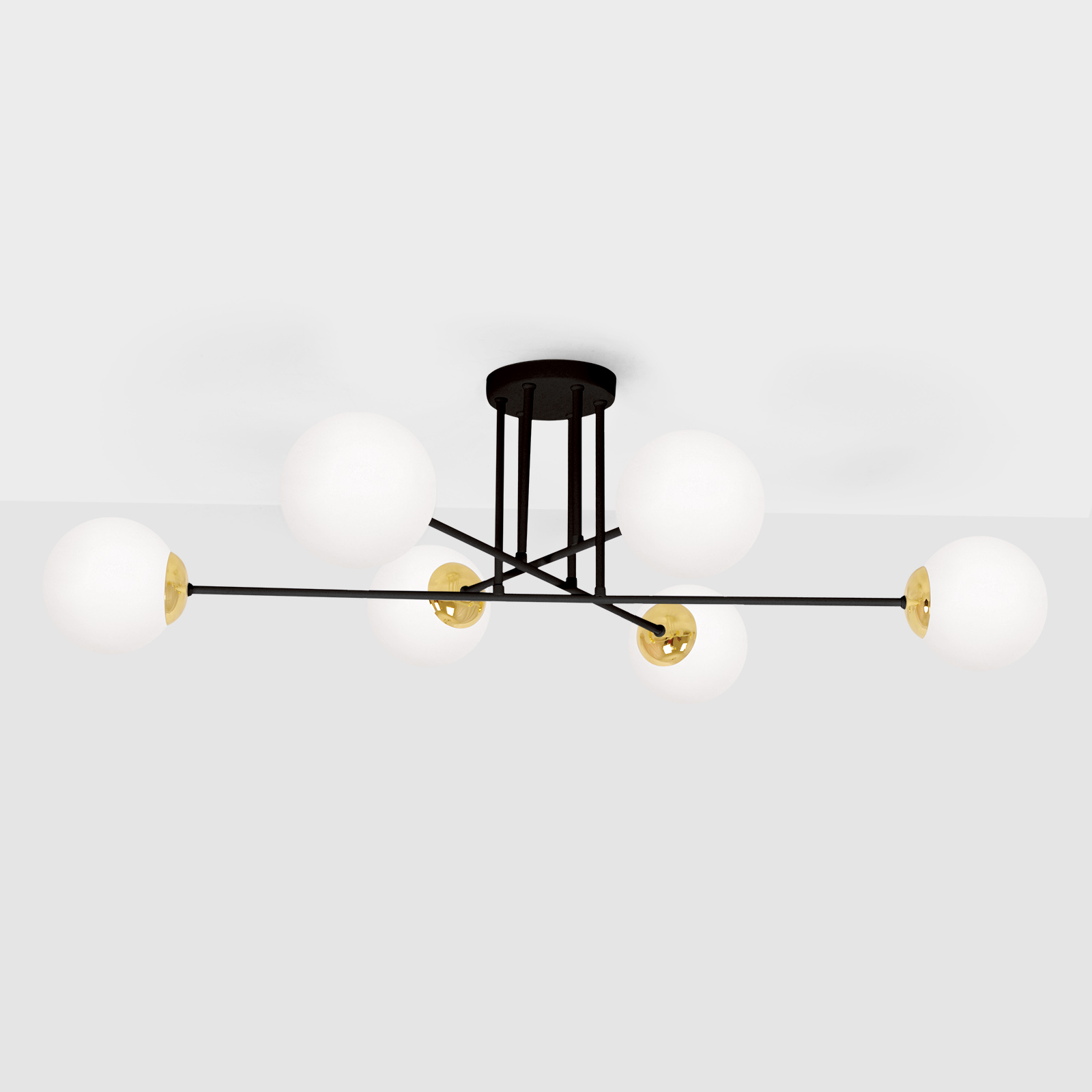 Lampa sufitowa Isla 6-punktowa w kolorze czarnym i patynowym, z sześcioma okrągłymi, białymi kloszami. Ułożona w centralnym punkcie, z metalową konstrukcją, która łączy klosze z okrągłym, czarnym mocowaniem.