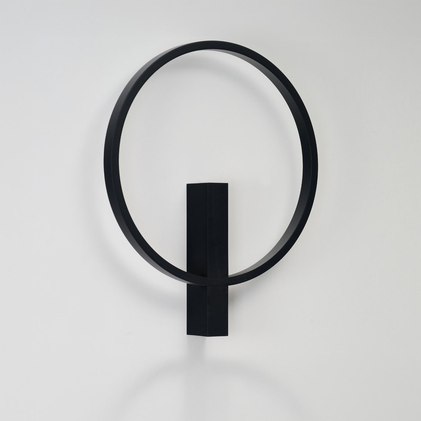 Kinkiet LED Arte 25W CCT w kolorze czarnym, o okrągłej, minimalistycznej formie. Produkt zamocowany na ścianie w pozycji pionowej, z prostokątną podstawą. Tło jasne, co podkreśla elegancki design.