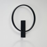 Kinkiet LED Arte 25W CCT w kolorze czarnym, o okrągłej, minimalistycznej formie. Produkt zamocowany na ścianie w pozycji pionowej, z prostokątną podstawą. Tło jasne, co podkreśla elegancki design.