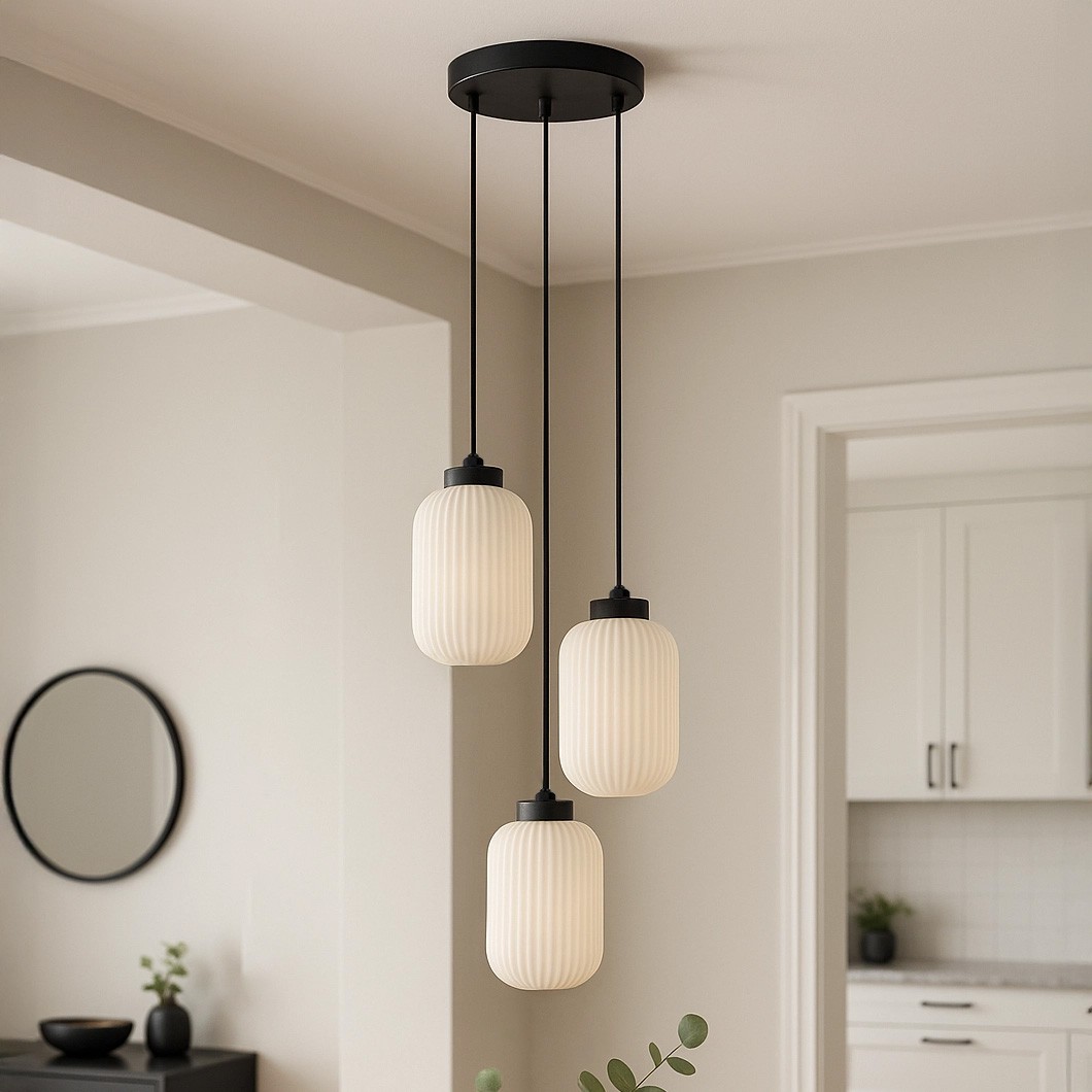 Lampa wisząca Vilar z trzema kloszami E27 w kolorze czarnym i białym. Klosze o owalnym kształcie z teksturowanym, matowym szkłem, zawieszone na czarnych linkach. Produkt zamontowany do sufitu w nowoczesnym wnętrzu.
