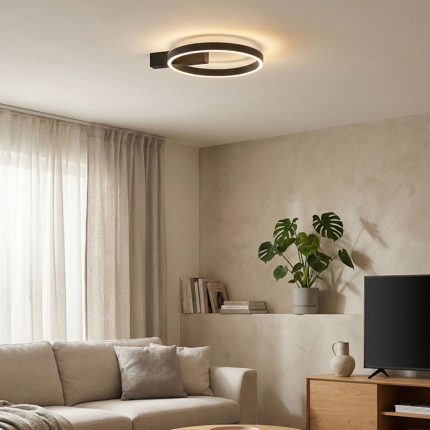 Czarna lampa sufitowa Arte z dwoma źródłami LED o mocy 50W, w kształcie okręgu z podświetleniem, zamontowana na suficie. Lampa w minimalistycznym stylu, idealna do nowoczesnych wnętrz. W tle widoczna roślina i elementy umeblowania.