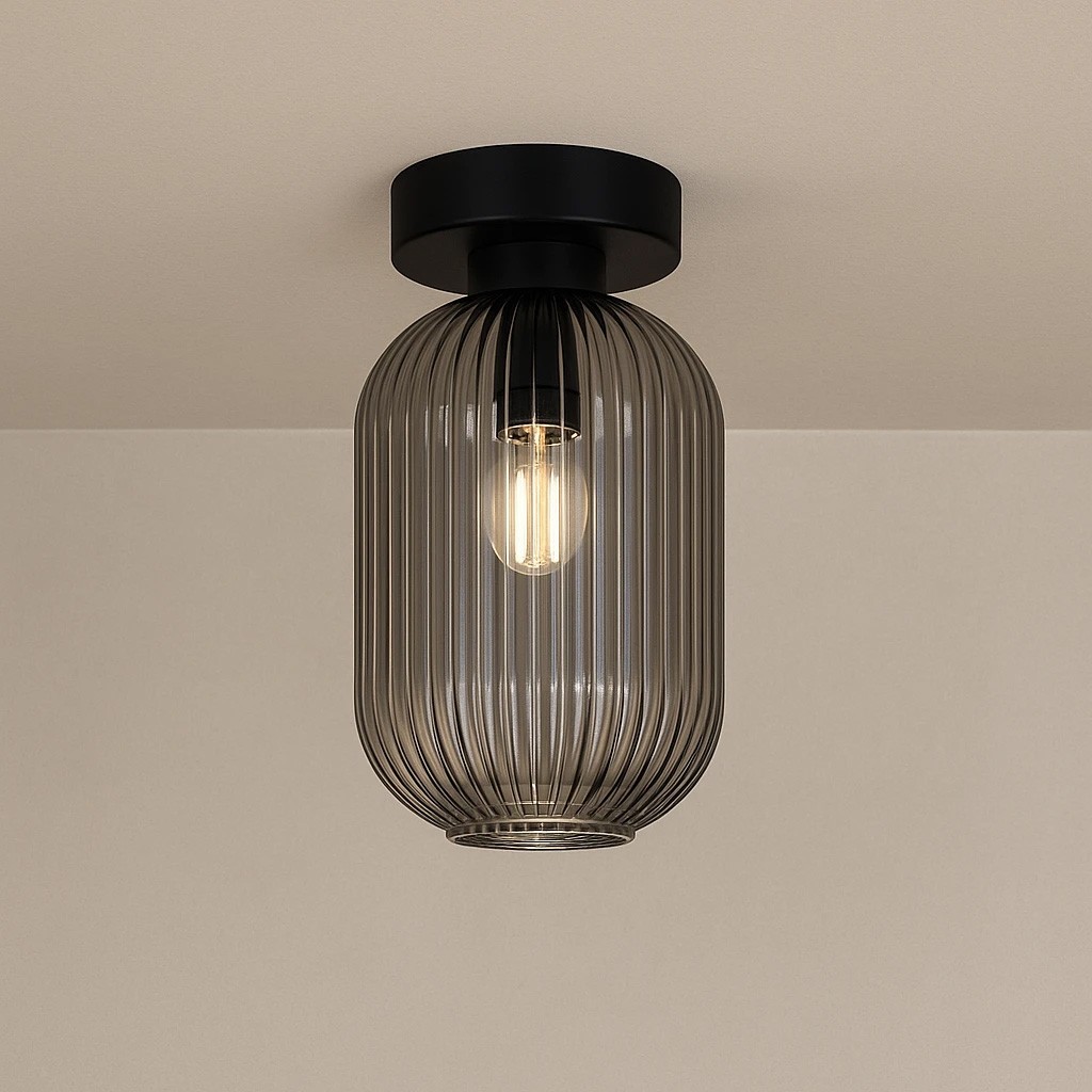 Lampa sufitowa Silva w kolorze czarnym i grafitowym, z przezroczystym, żebrowanym kloszem. Zawiera jedno gniazdo E27. Ujęcie z dołu, pokazujące lampę wiszącą na suficie, z widoczną żarówką w środku. Tło w jasnym odcieniu.