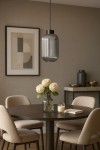 Lampa wisząca Silva D14 z czarnym metalowym mocowaniem i grafitowym, żebrowanym kloszem. Zawieszona nad okrągłym stołem, w otoczeniu jasnych krzeseł i dekoracji, tworzy elegancką aranżację wnętrza.