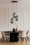 Lampa wisząca Silva 3xE27 w kolorze czarnym i grafitowym, z trzema cylindrycznymi kloszami o żłobionej powierzchni. Zawieszona na długich czarnych linkach, umieszczona nad okrągłym, ciemnym stołem w nowoczesnym wnętrzu z jasnymi krzesłami.