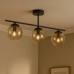 Lampa sufitowa Delta z trzema bursztynowymi kloszami na czarnym stelażu. Klosze mają okrągły kształt, a całość jest zamocowana do sufitu. Widoczne żarówki E14 w każdej oprawie. Tło w neutralnym kolorze.