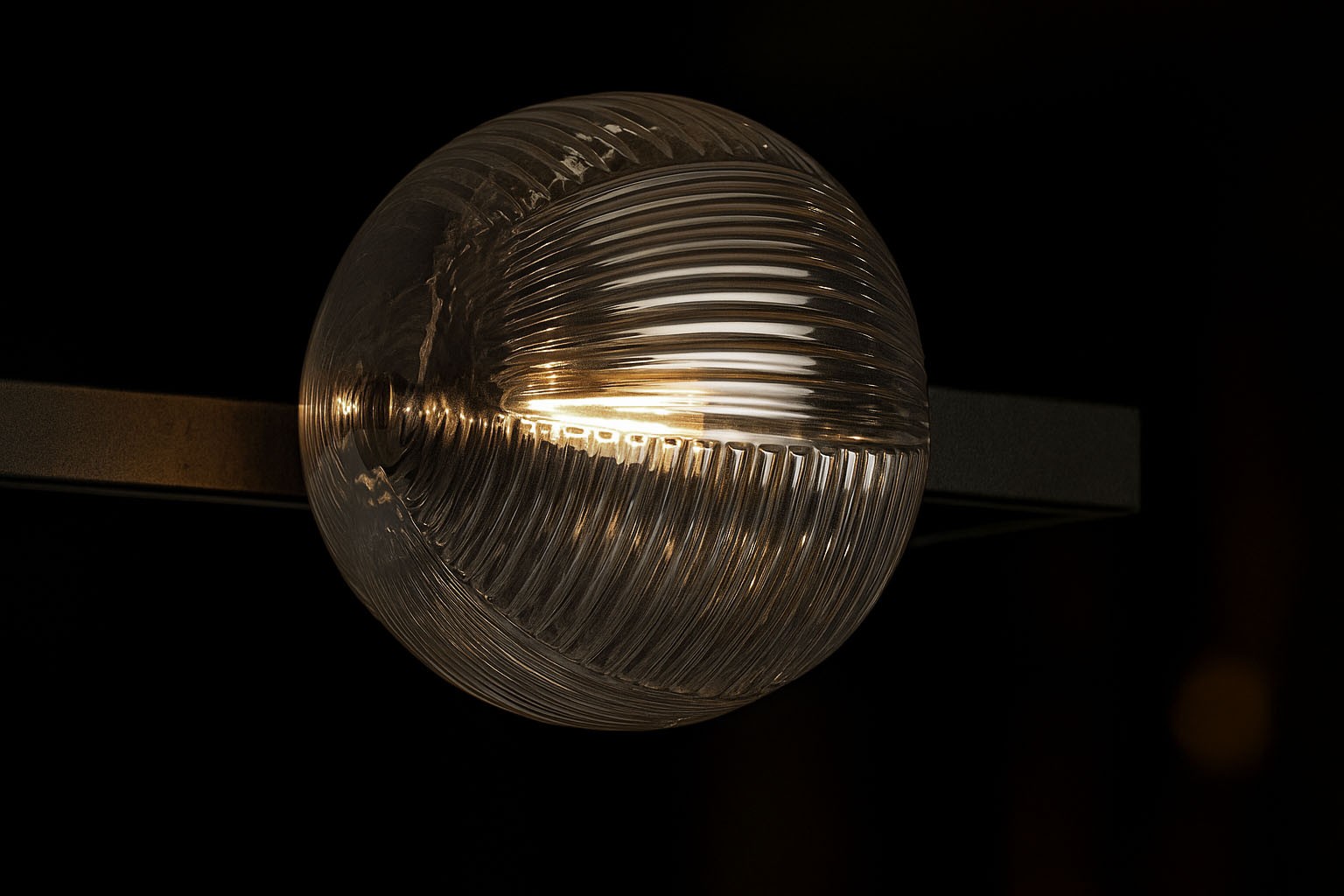 Lampa sufitowa Parma 2xG9 w kolorze czarnym z przezroczystym kloszem. Zbliżenie na okrągły klosz z teksturowanej szkła, zamontowany na prostokątnej podstawie, emitujący ciepłe światło. Tło ciemne, podkreślające detale lampy.