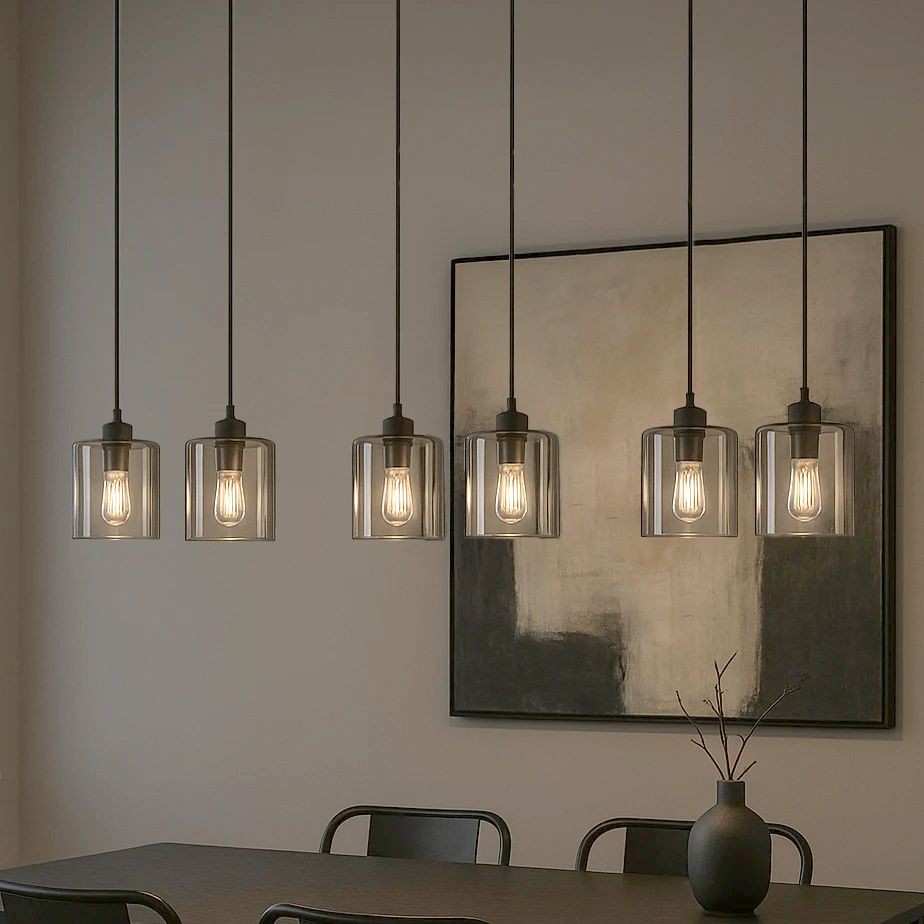 Lampa wisząca Miri z sześcioma kloszami E27 w kolorze czarnym i grafitowym, zawieszona na długich linkach. Klosze z przezroczystego szkła, ukazujące żarówki. Tło stanowi minimalistyczny obraz w odcieniach szarości.