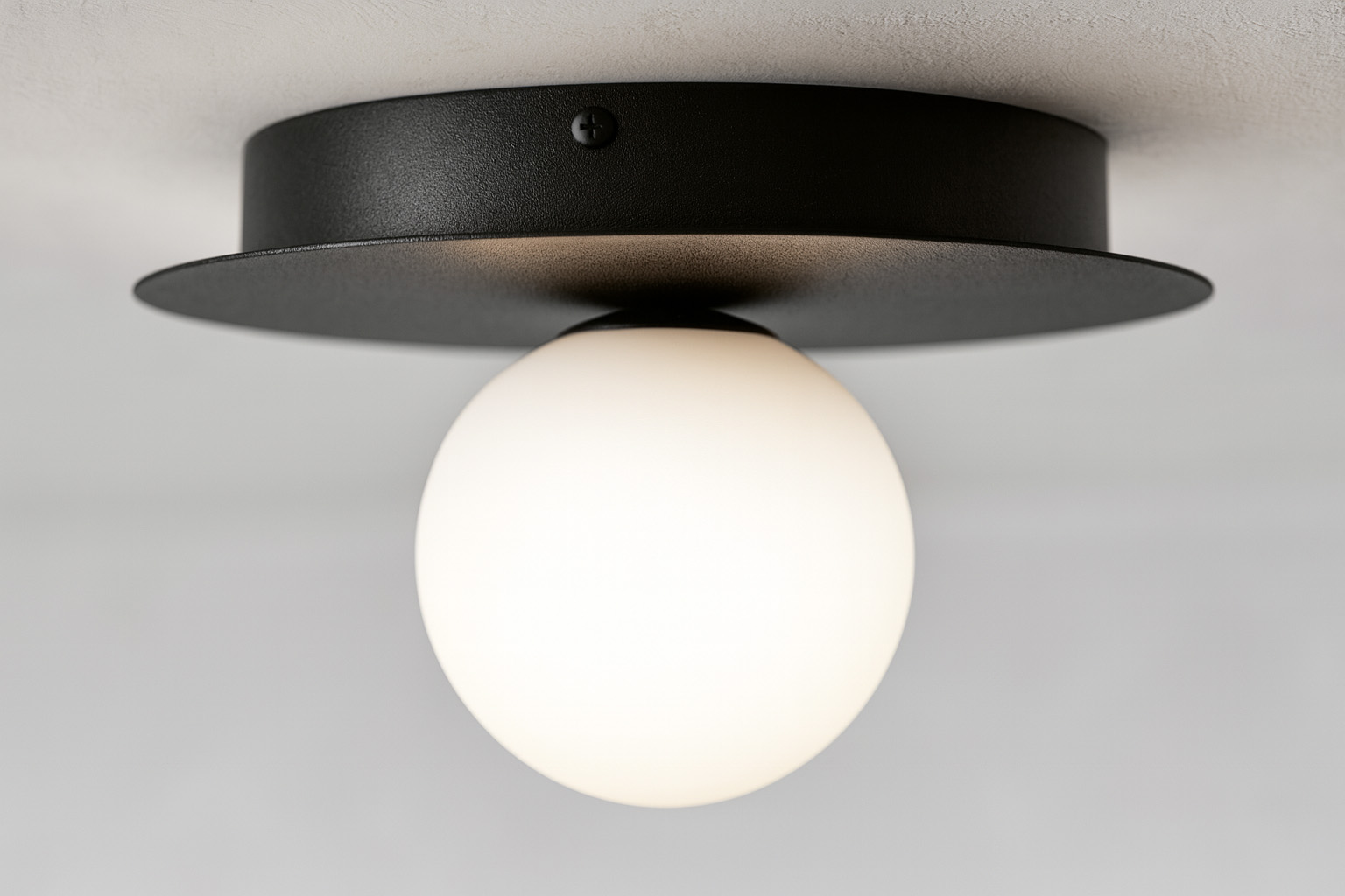 Lampa sufitowa Robin D25 w kolorze czarnym i białym, z okrągłym kloszem z matowego szkła. Umieszczona na okrągłej podstawie, widok z dołu, podkreślający jej minimalistyczny design i elegancką formę.