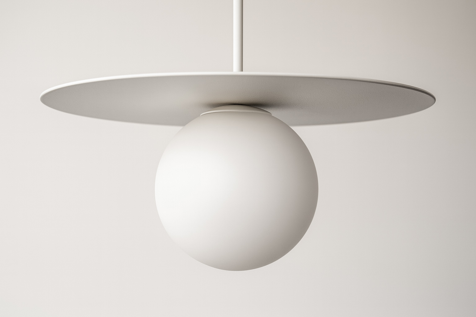 Lampa wisząca Robin D25 z białym kloszem w kształcie kuli zawieszona na cienkim przewodzie, z okrągłą, płaską podstawą. Prosta forma, minimalistyczny design, idealna do nowoczesnych wnętrz. Tło jasne, jednolite.